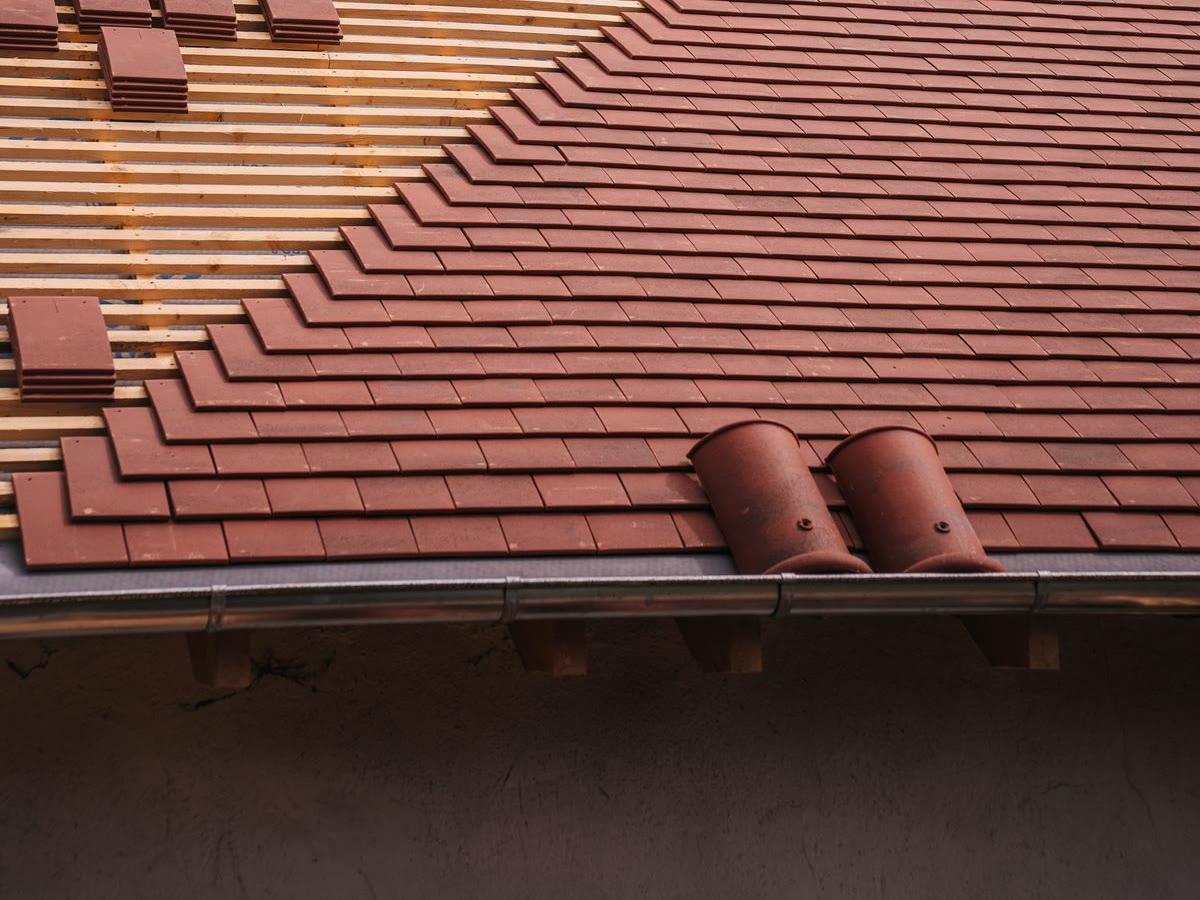 Pose de tuiles neuves sur une toiture